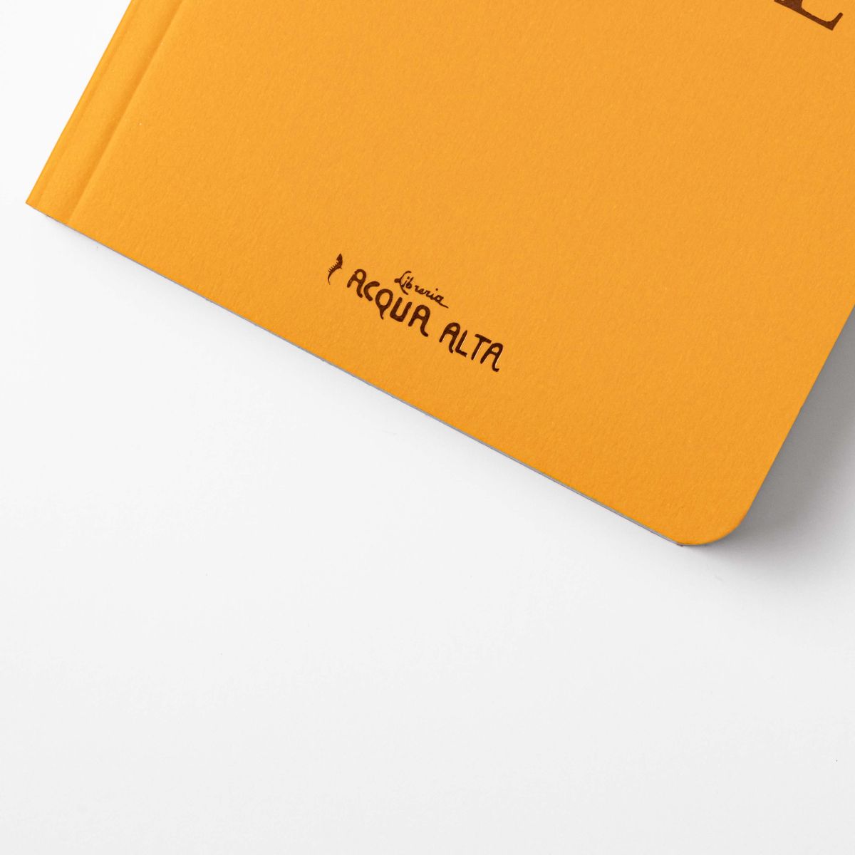 Close-up of the corner of the yellow cover of A Brief History of Venice featuring the Libreria Acqua Alta logo